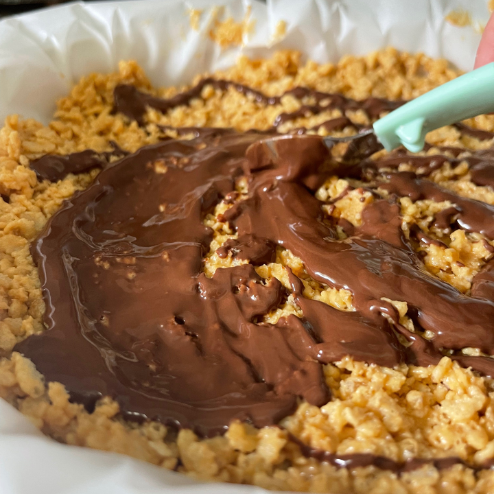 spreading melted chocolate over healthy rice crispy treats